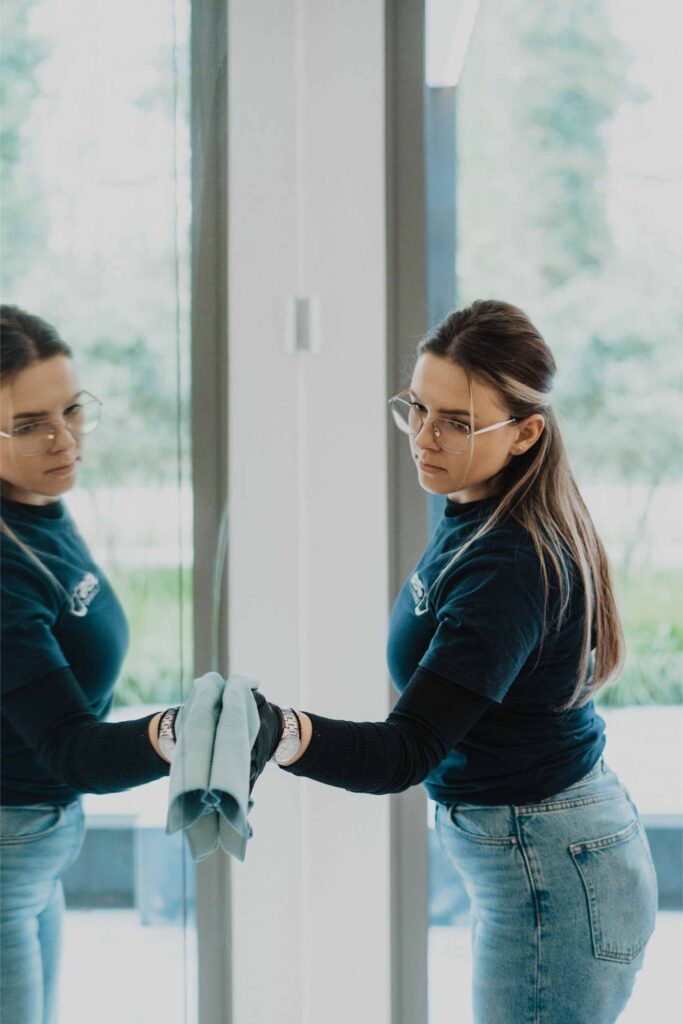 Twee medewerksters van JES Cleaning zemen een raam in een kantoor